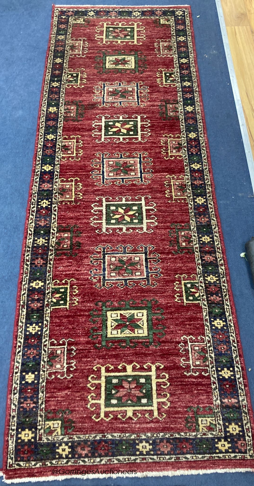 A Caucasian style red ground runner, 240 x 80cm